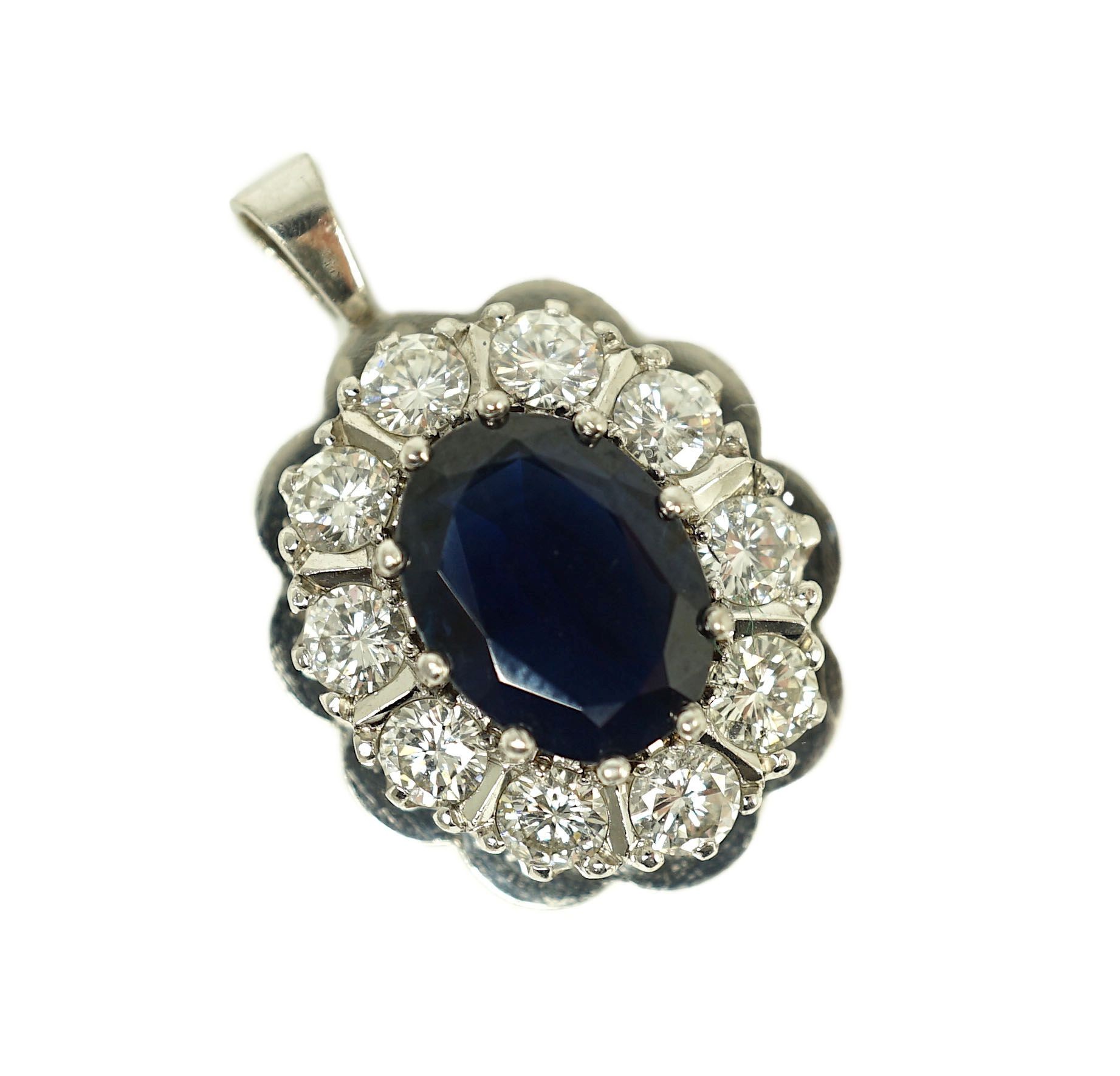 A modern 18ct white gold, sapphire and diamond set oval cluster pendant